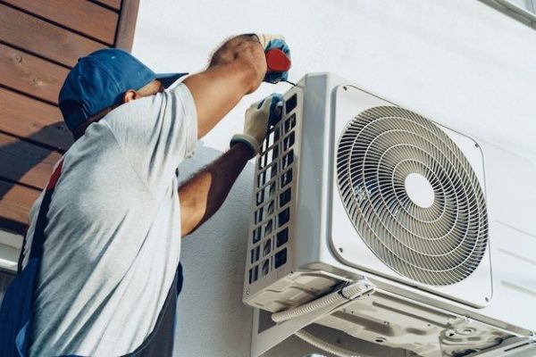 Premium Photo _ Repairman in uniform installing the outside unit of air conditioner Premium Photo _ Repairman in uniform installing the outside unit of air conditioner